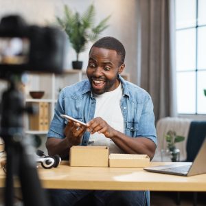 African man filming video while unpacking new smartphone