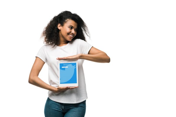 KYIV, UKRAINE - MAY 29, 2019: happy african american girl holding digital tablet with twitter app on