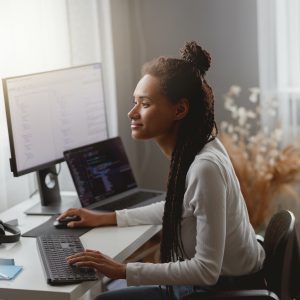 Side view of mixed-race young professional concentrated skilled web expert working on computer