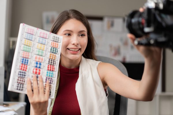 Young fashion designer woman filming live video for selling clothes