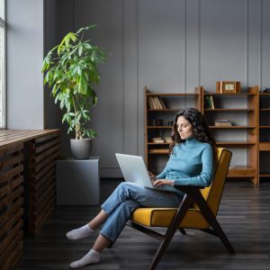 Young woman freelancer work on laptop at home typing email to client or shopping in internet store